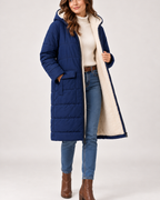 Women's navy long puffer coat shown open with contrast lining