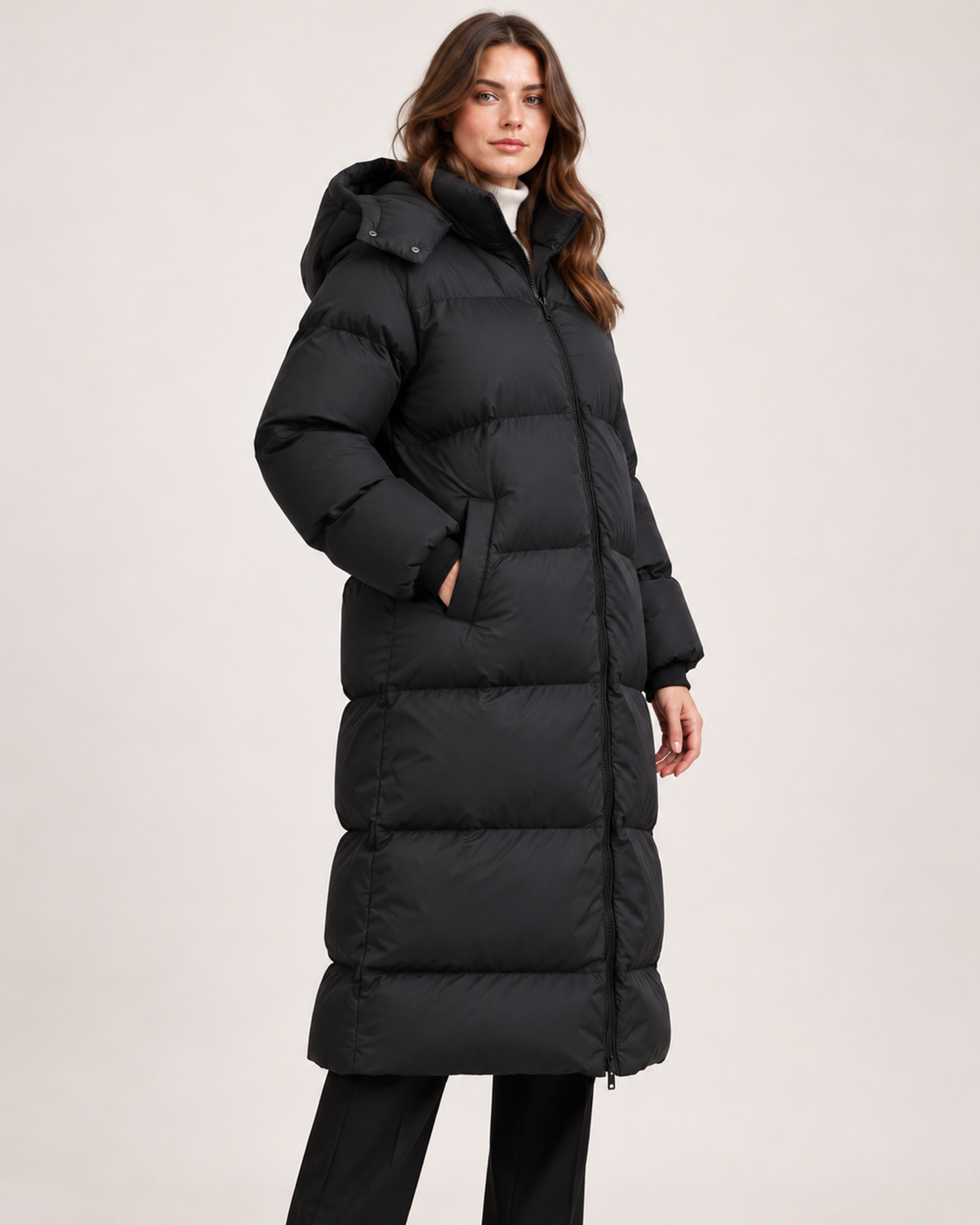 Women's black long hooded puffer coat side and pocket view