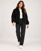Women’s black fleece jacket full body walking view