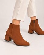 Women's brown suede heeled ankle boots worn