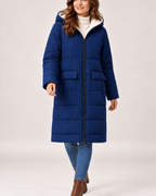 Women's navy long puffer coat styled in a walking pose